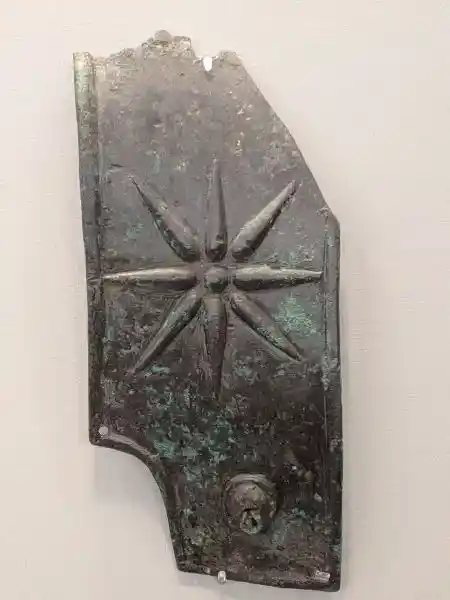 Bronze epaulette of a cuirass featuring an embossed eight-pointed star from an ancient statue